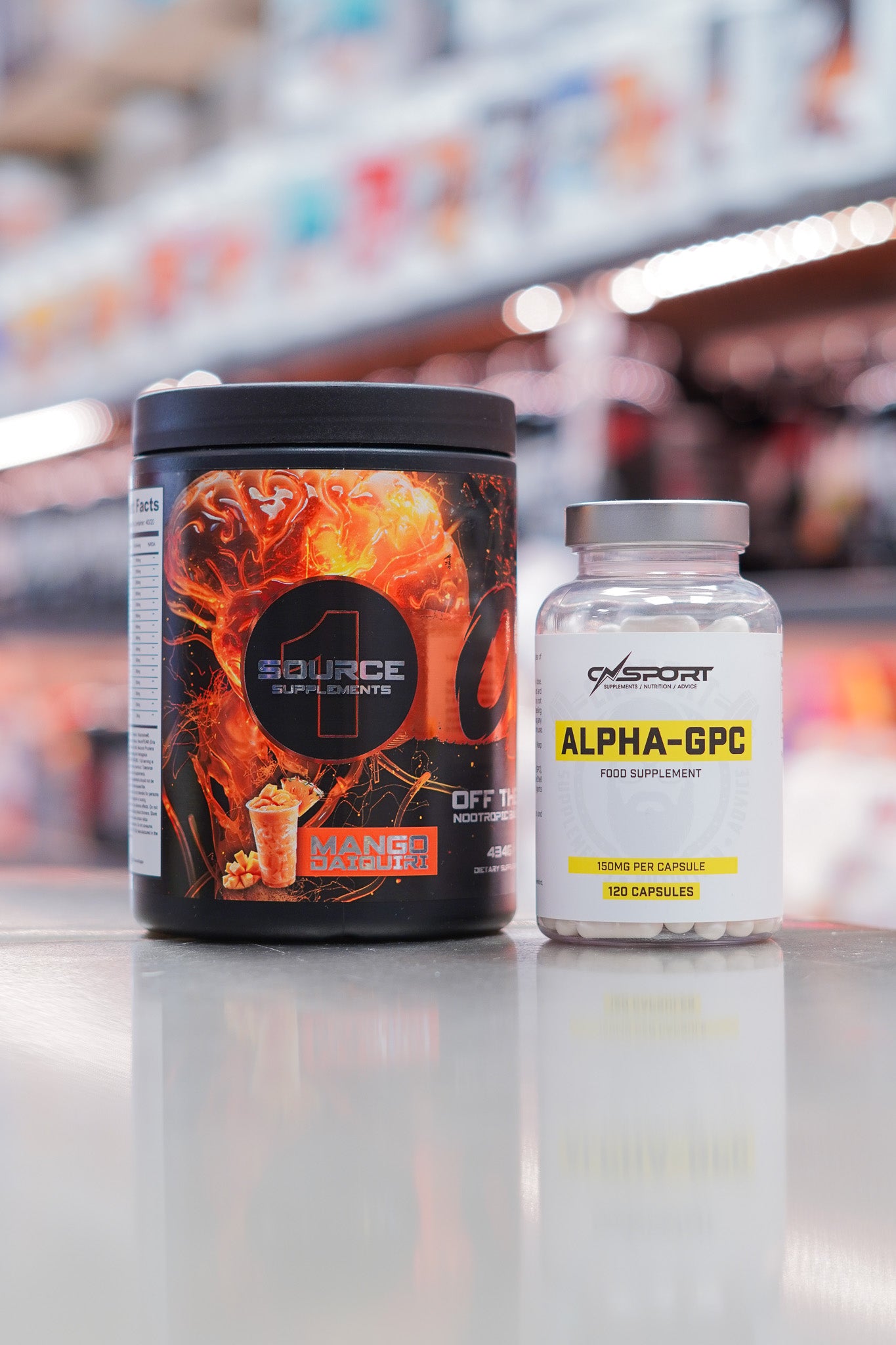 1 Source Supplements OTS pre-workout Mango Daiquiri flavour (434g) with CNSport Alpha-GPC 150mg capsules (120 capsules) displayed on supplement store counter.
