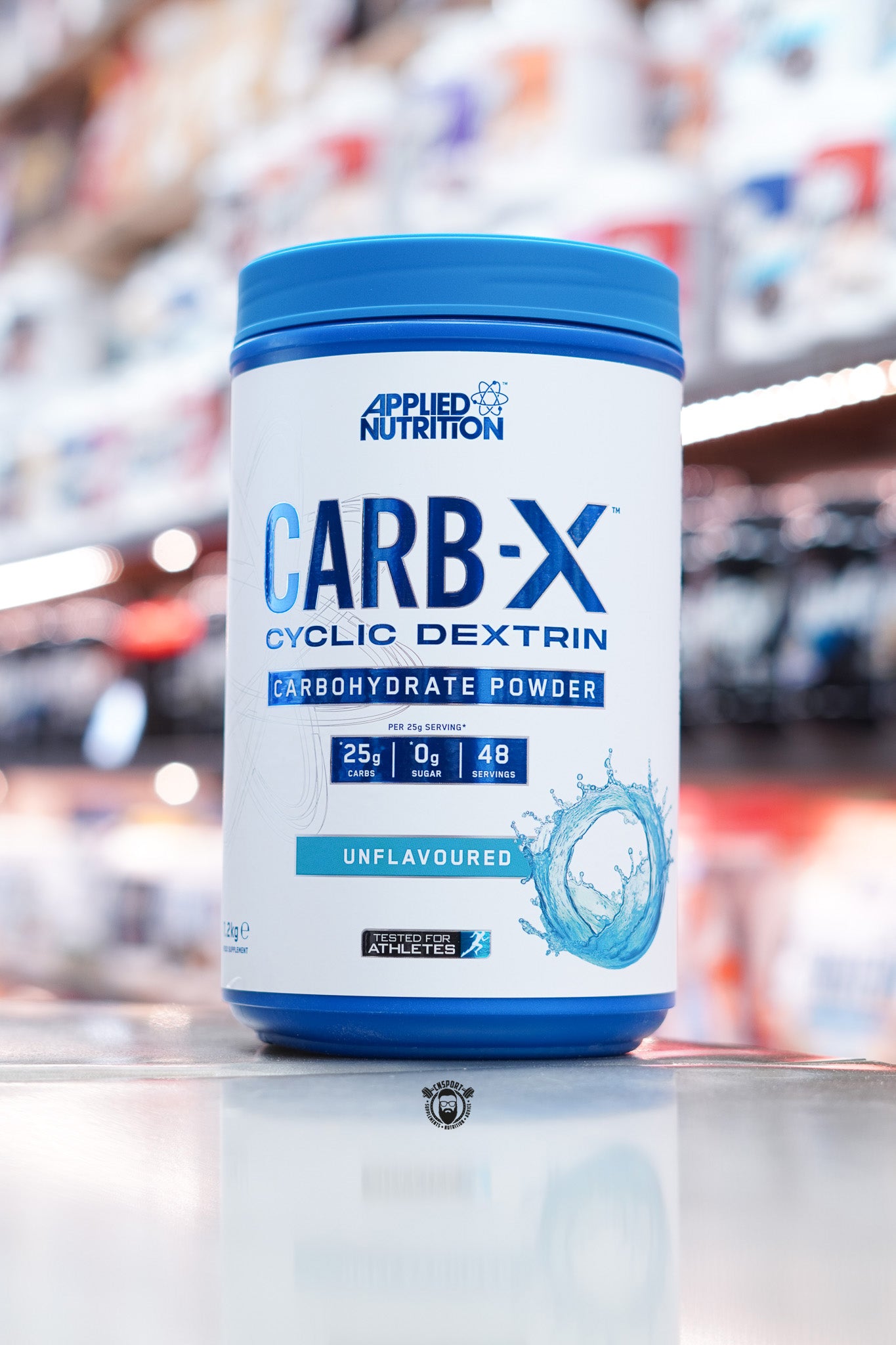 Front-facing image of Applied Nutrition Carb-X Unflavoured variant with blue water splash design and clear carbohydrate information on the label.
