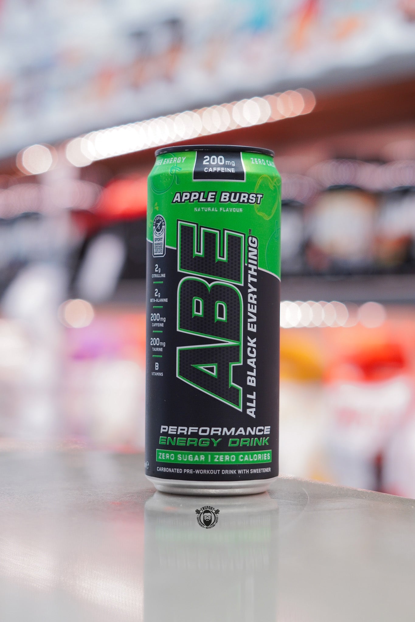 Applied Nutrition ABE Performance Energy Drink, Apple Burst flavour, 330ml can with 200mg caffeine, zero sugar and zero calories, displayed on supplement store counter.