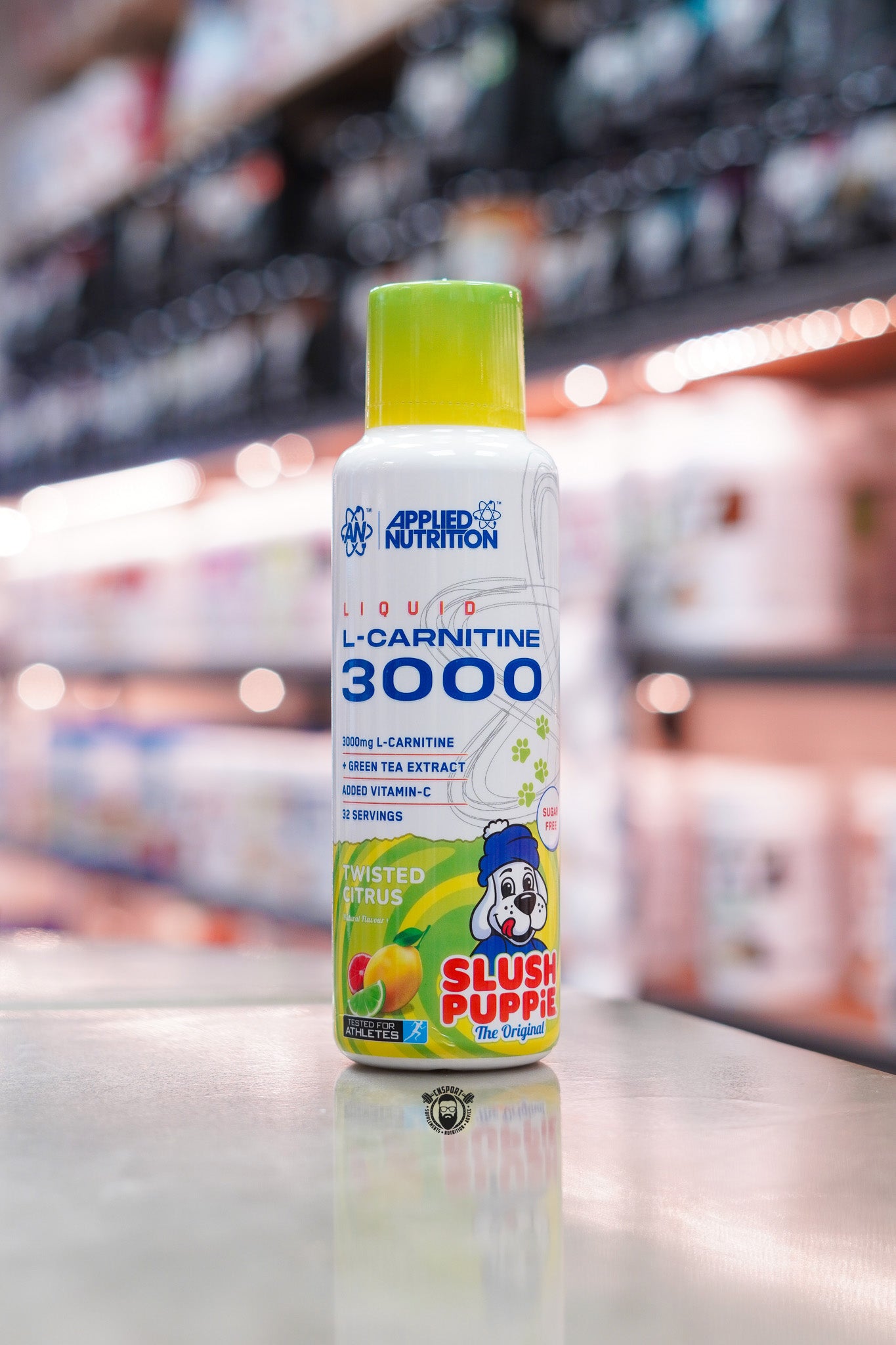 Applied Nutrition L-Carnitine Liquid 3000 Twisted Citrus Slush Puppie flavour bottle displayed on a supplement shop counter.