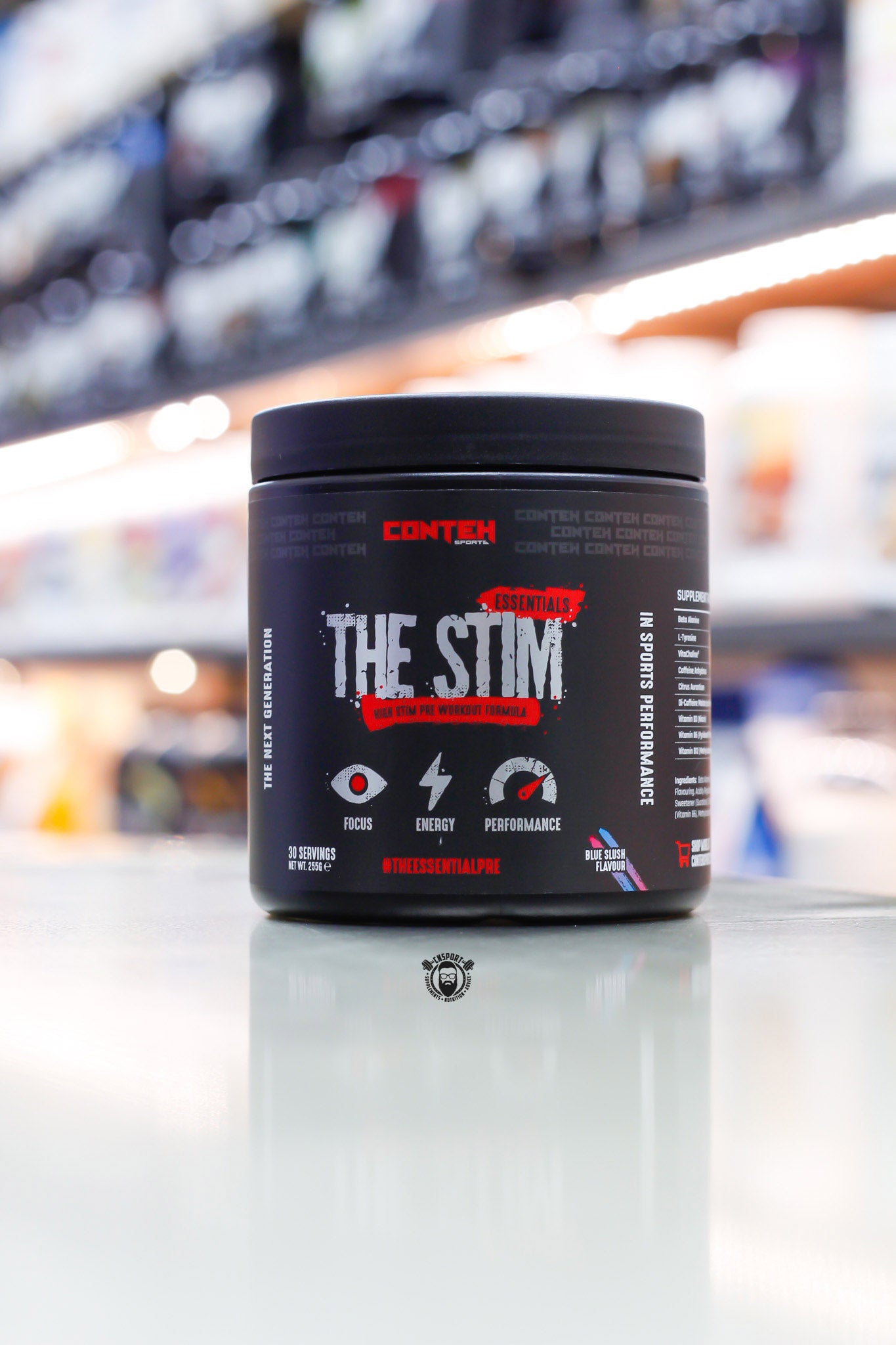 Conteh Sports The Stim pre-workout, Blue Slush flavour, 30 servings (255g) black tub front view on supplement store counter.
