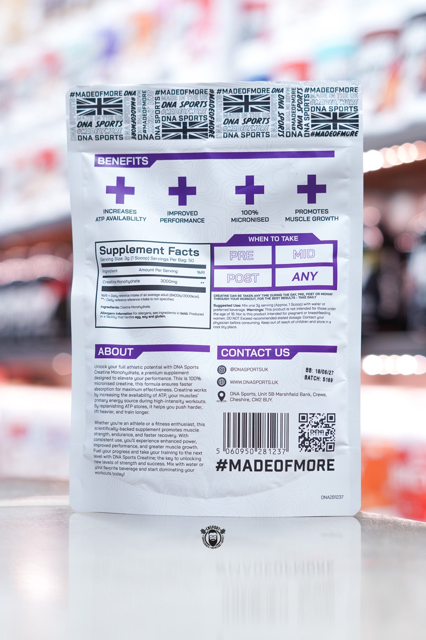Close-up of the DNA Sports Creatine Monohydrate pouch showing supplement facts, benefits, directions, and contact details with purple and white design.