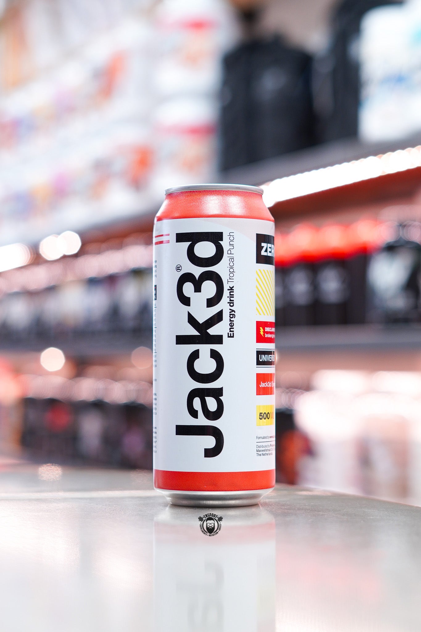 Jack3d Energy Drink Tropical Punch 500ml zero sugar can displayed on supplement store counter.