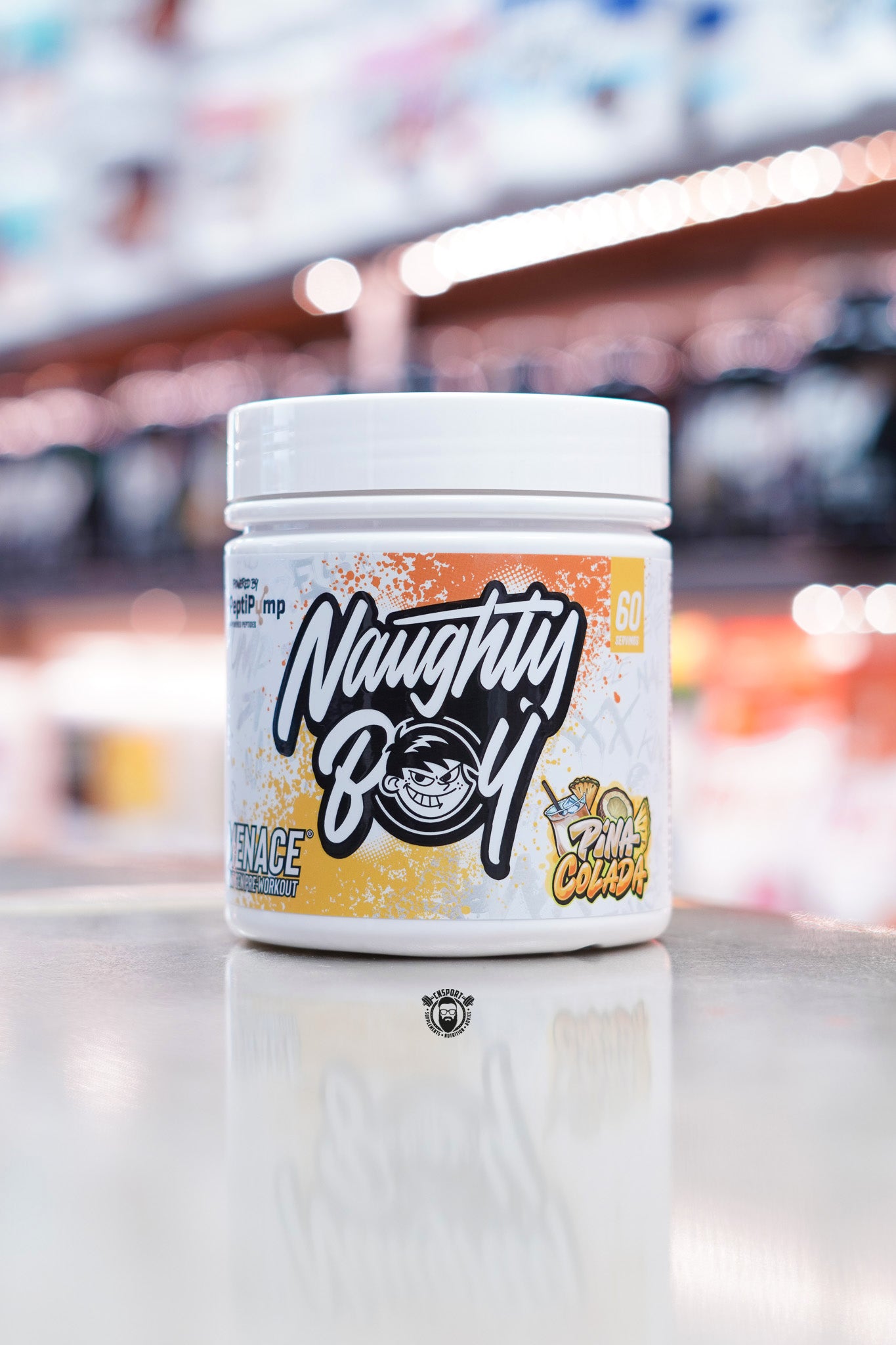 White tub of Naughty Boy Menace II Pre-Workout with orange and yellow splatter design, bold logo, and illustrated pina colada flavour graphic on the label.