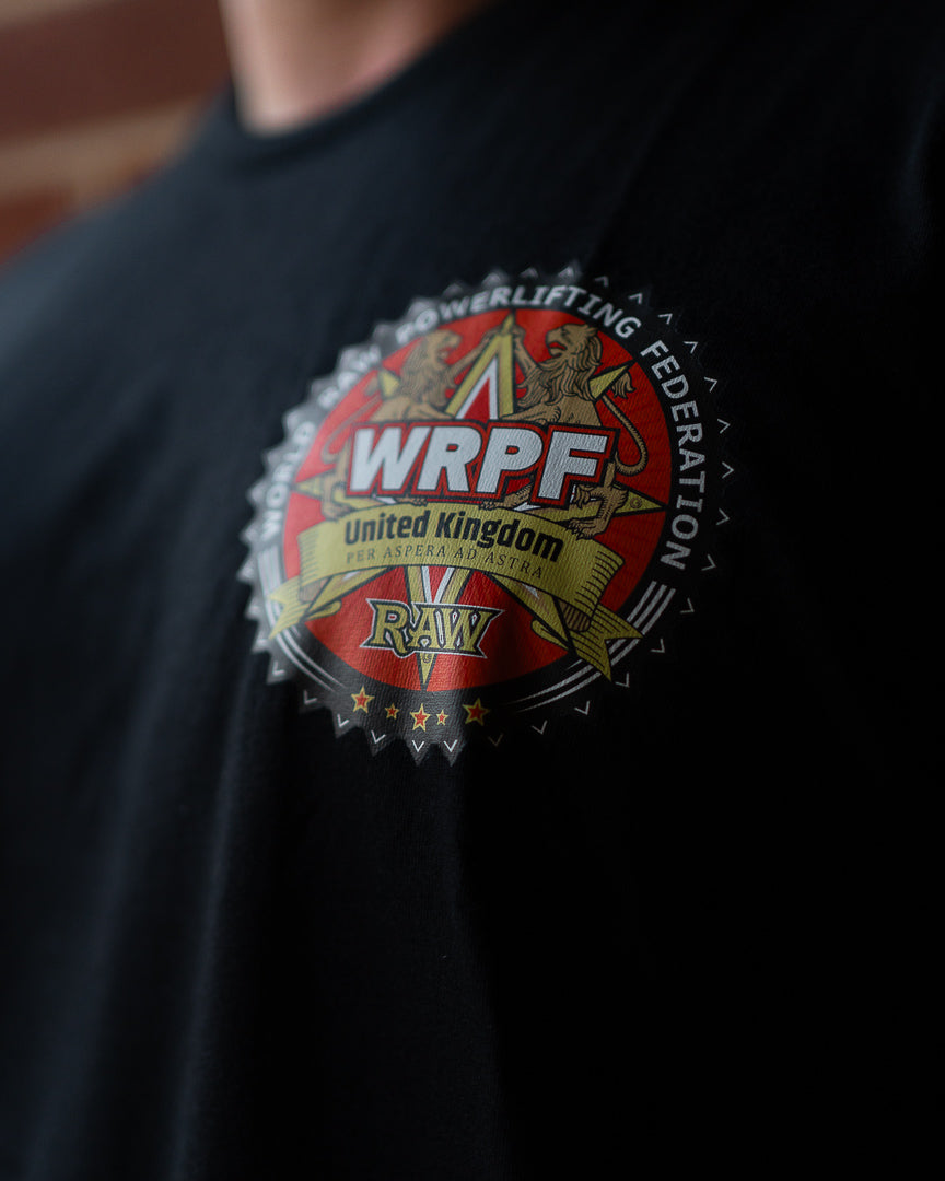 Close-up of the WRPF UK logo printed on the chest of a black sweatshirt, featuring a red and gold crest with lions, stars, and the words “WRPF United Kingdom RAW