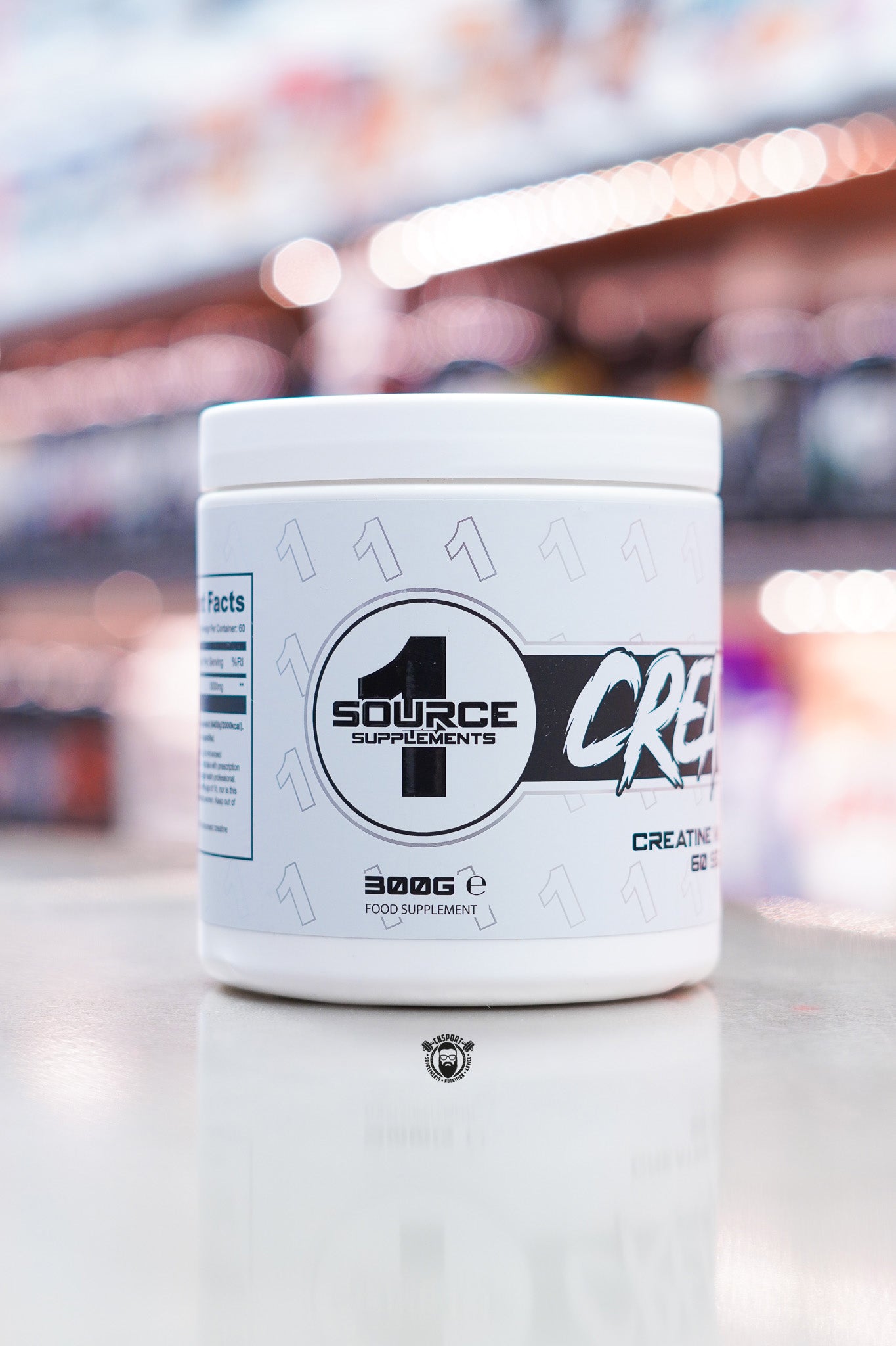 1 Source Supplements Creatine Monohydrate tub showing side branding and 300g size, displayed on supplement store counter.