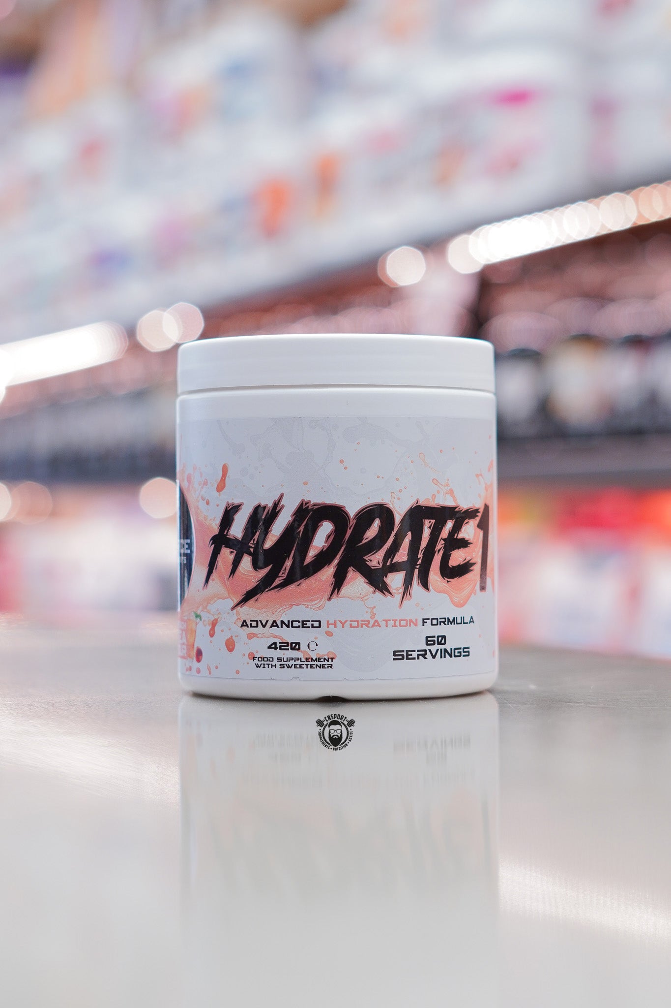 Front-facing 1 Source Supplements Hydrate advanced hydration formula tub showing Hydrate branding, 60 servings, on a reflective retail counter.
