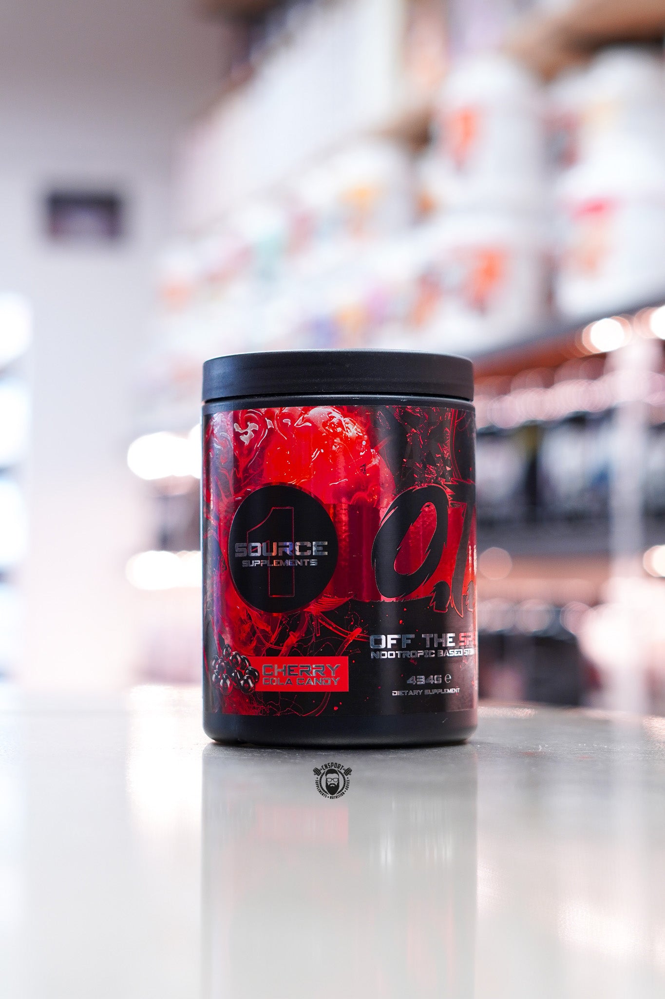 Source Supplements Off The Spectrum OTS Pre-Workout Cherry Cola Candy flavour, 434g tub with 40 servings, displayed on a supplement store counter with red and black label design.