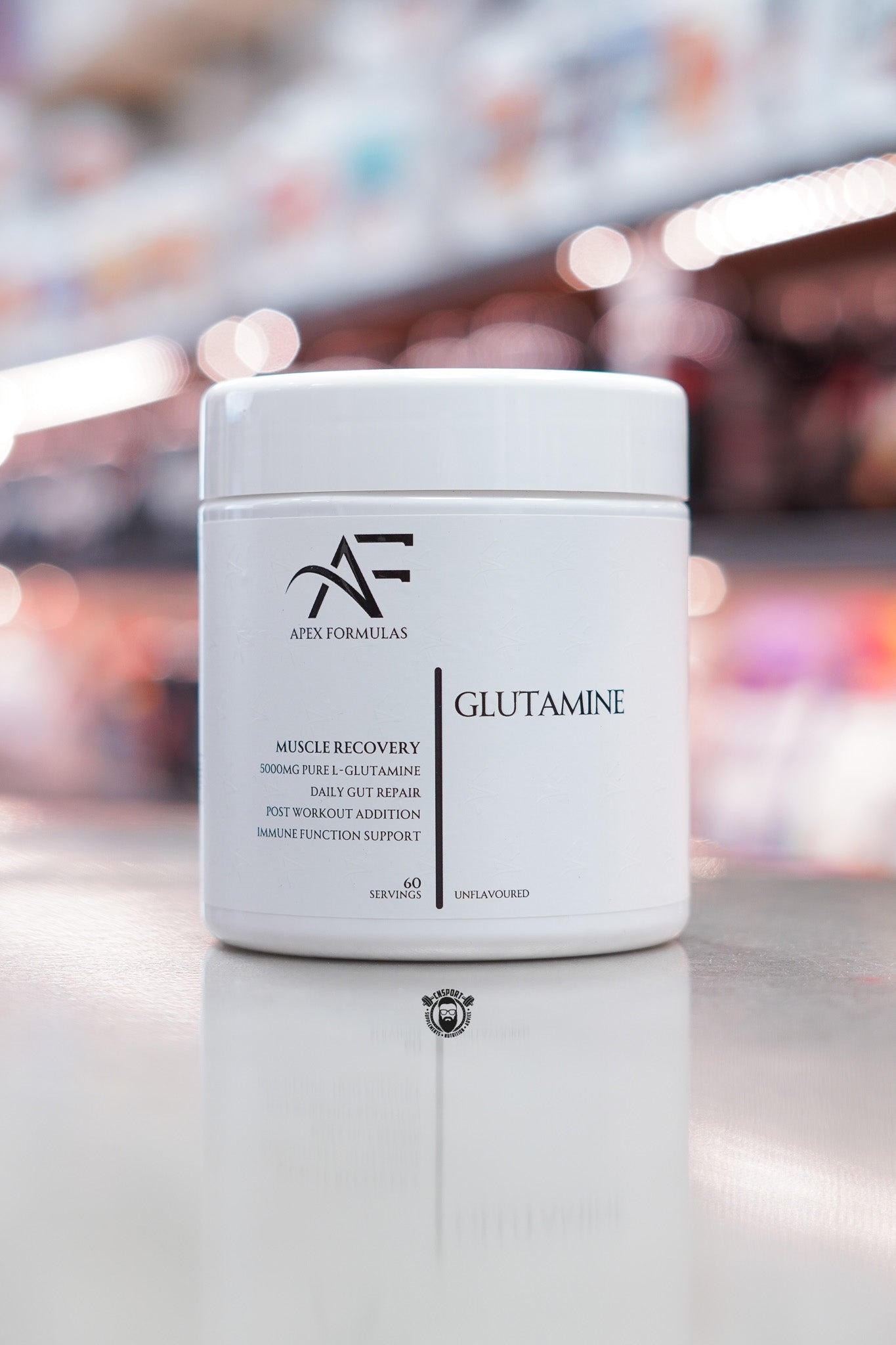 Apex Formulas Glutamine powder, unflavoured, 60 servings, 5000mg pure L-Glutamine per serving, white tub displayed on supplement store counter.