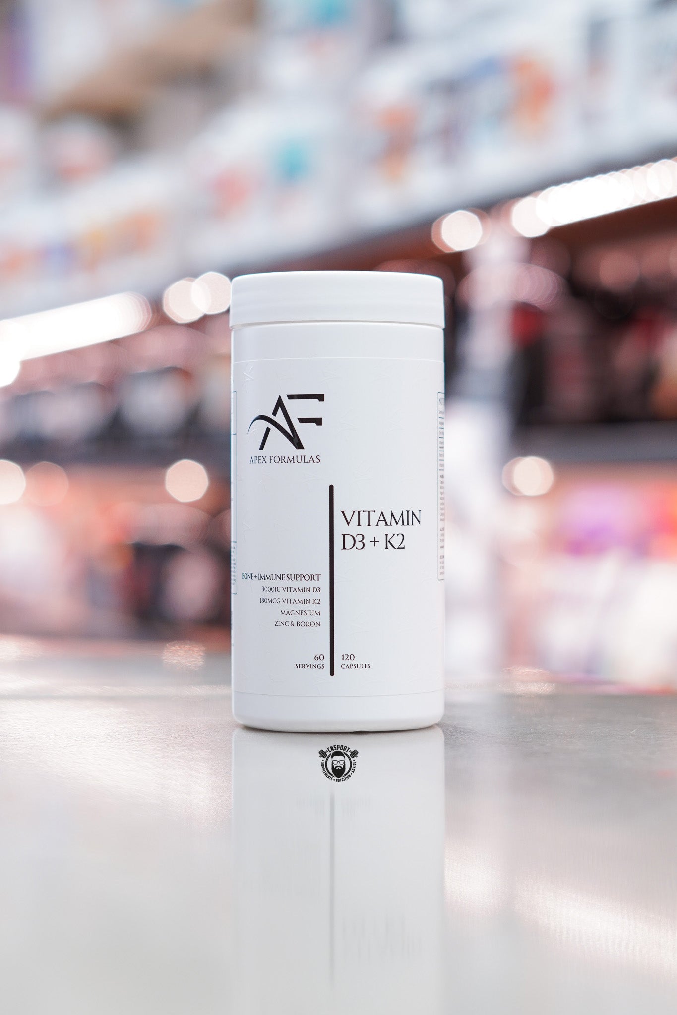 Apex Formulas Vitamin D3 + K2 capsules, 120 capsules, bone and immune support formula with magnesium, zinc and boron, white bottle displayed on supplement store counter.