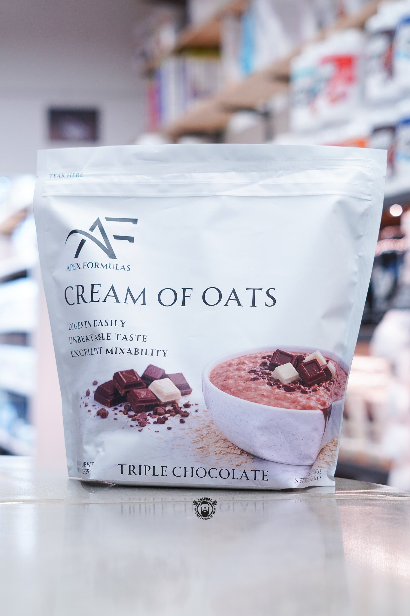 Apex Formulas Cream of Oats Triple Chocolate flavour 2kg pouch displayed on supplement store counter.
