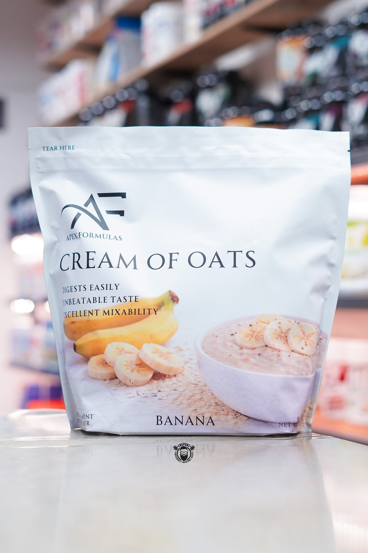 Apex Formulas Cream of Oats Banana flavour pouch displayed on a supplement store counter.