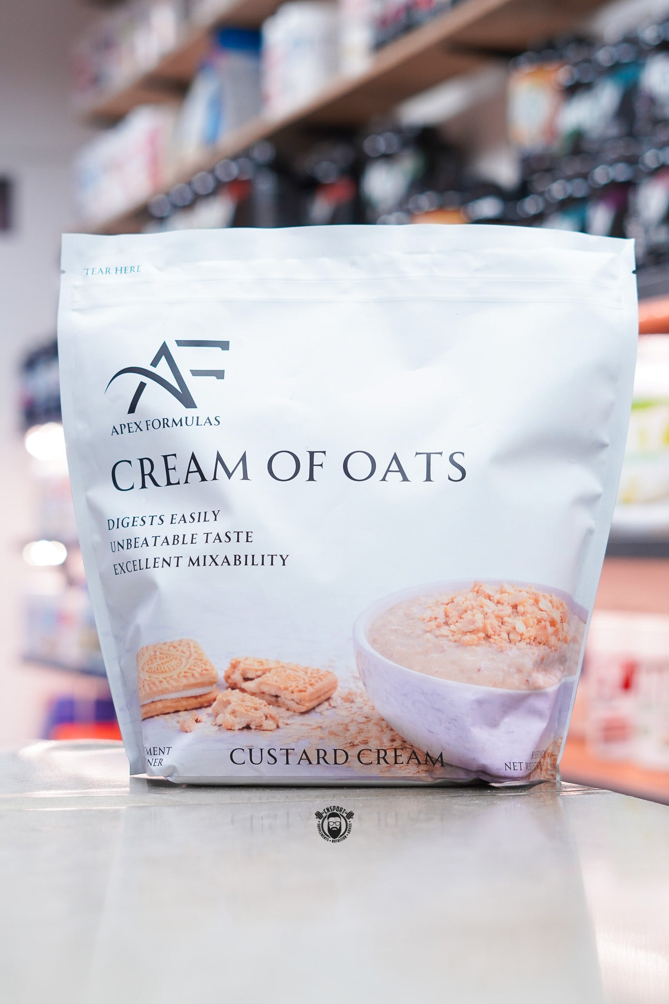 Apex Formulas Cream of Oats Custard Cream flavour pouch displayed on a supplement store counter.