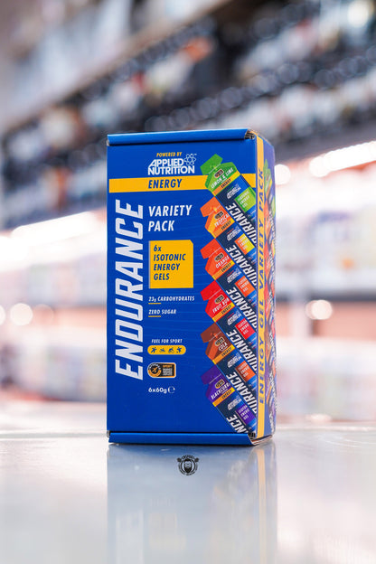 Applied Nutrition Endurance Energy Variety Pack containing 6 isotonic energy gels with mixed flavours displayed on supplement store counter with blurred retail background