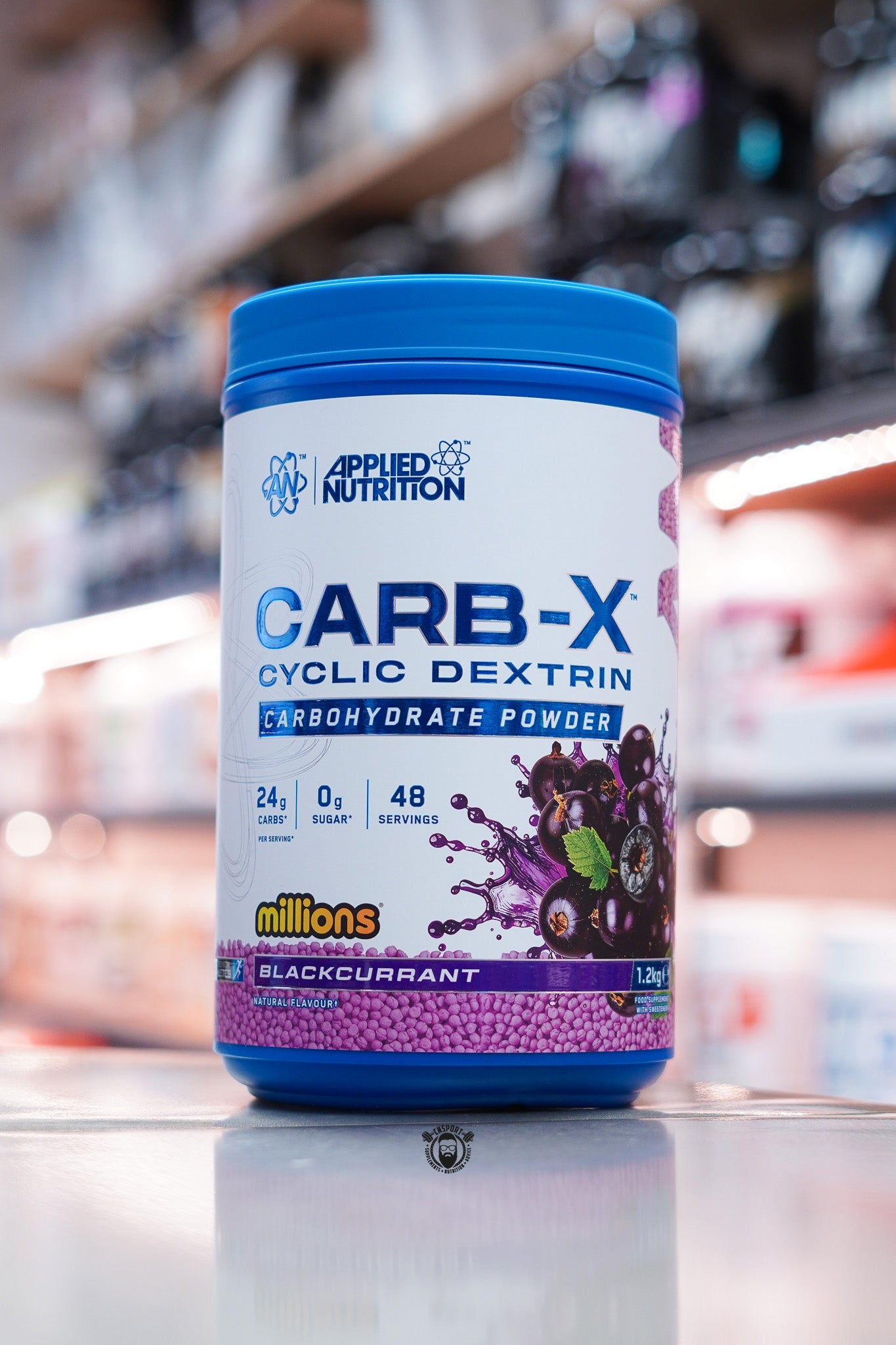 Applied Nutrition Carb-X Cyclic Dextrin carbohydrate powder, Blackcurrant Millions flavour, 1.2kg tub on supplement store counter.