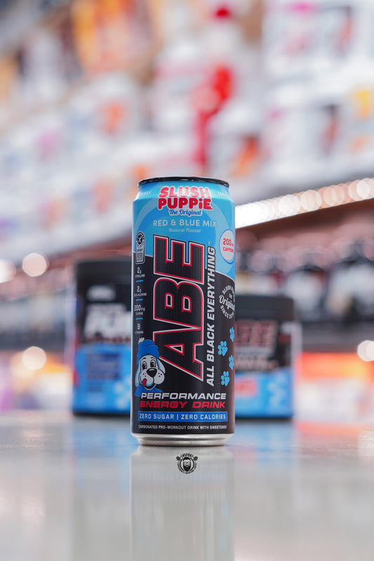 A can of Applied Nutrition ABE All Black Everything performance energy drink in Slush Puppie Red & Blue Mix flavour, featuring the Slush Puppie dog graphic, zero sugar, zero calories, and 200mg caffeine.