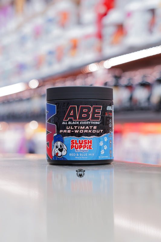 A black tub of Applied Nutrition ABE All Black Everything Ultimate Pre-Workout in Slush Puppie Red & Blue Mix flavour, featuring the Slush Puppie dog graphic on the label and stating 30 servings.