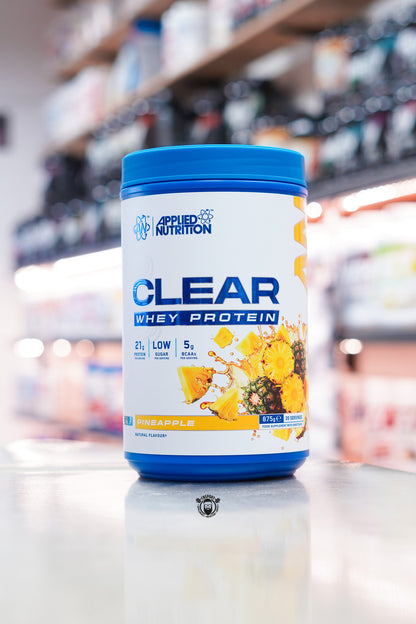 Applied Nutrition Clear Whey Protein Pineapple flavour 875g tub with 35 servings displayed on a supplement shop counter.