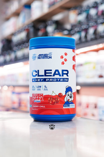 Applied Nutrition Clear Whey Protein Slush Puppie Cherry Chill flavour 875g tub displayed on a supplement shop counter.