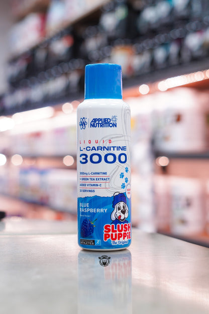 Applied Nutrition L-Carnitine Liquid 3000 Blue Raspberry Slush Puppie flavour bottle displayed on a supplement shop counter.