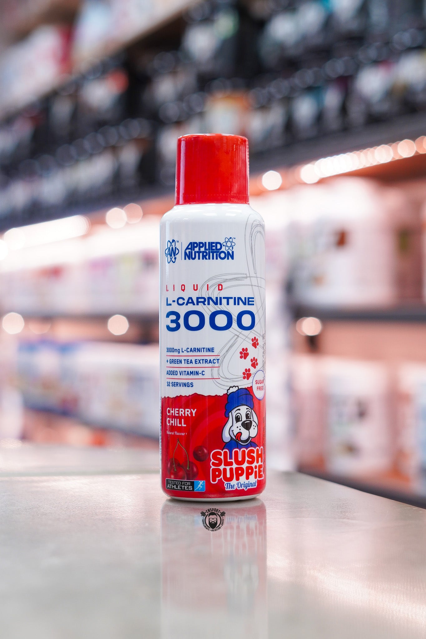 Applied Nutrition L-Carnitine Liquid 3000 Cherry Chill Slush Puppie flavour bottle with red cap displayed on a supplement shop counter.