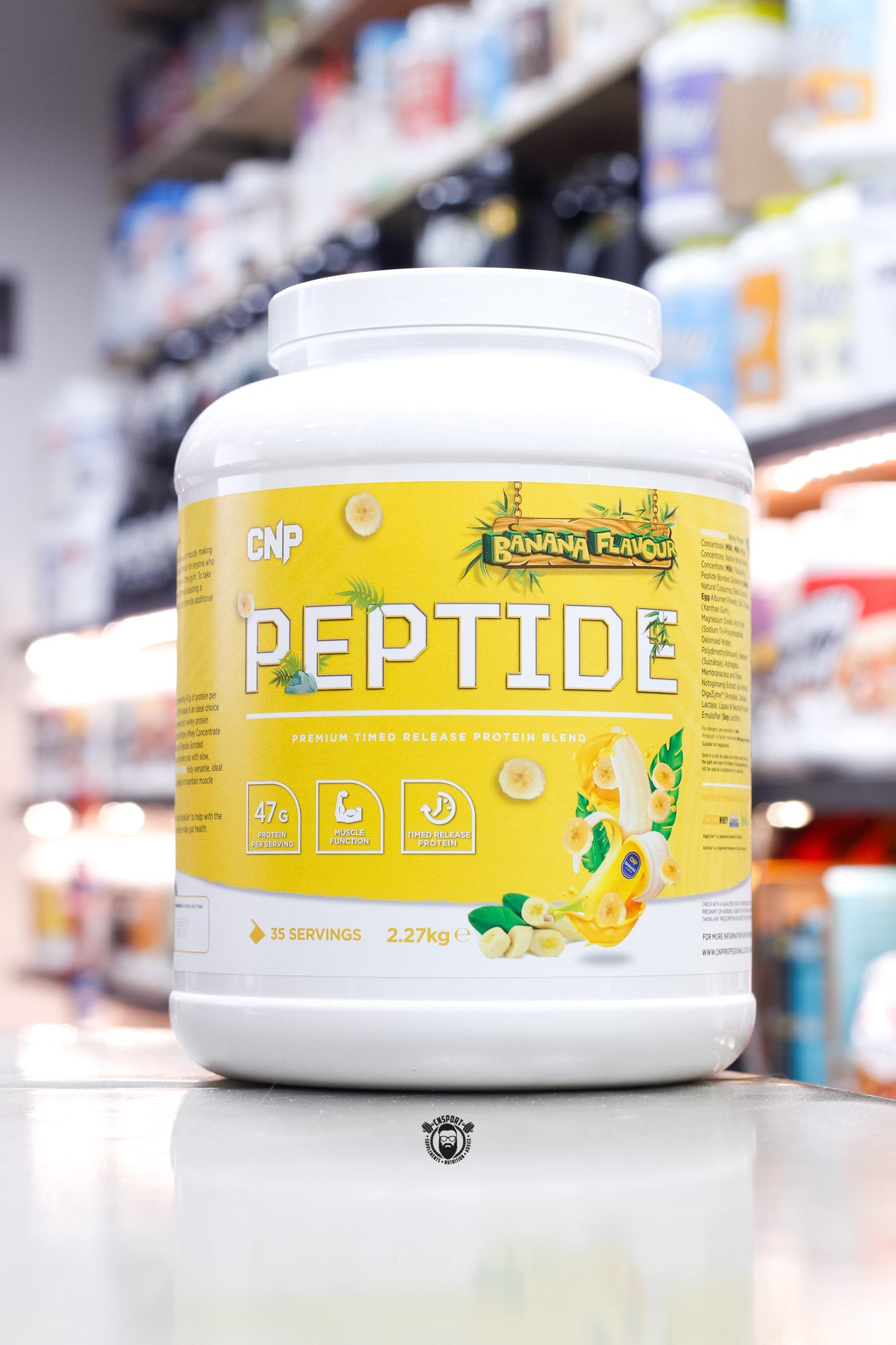 Large 2.27kg tub of CNP Peptide timed release protein blend in Banana Flavour, featuring a bright yellow label with banana graphics, highlighting 47g protein per serving and 35 servings per container.