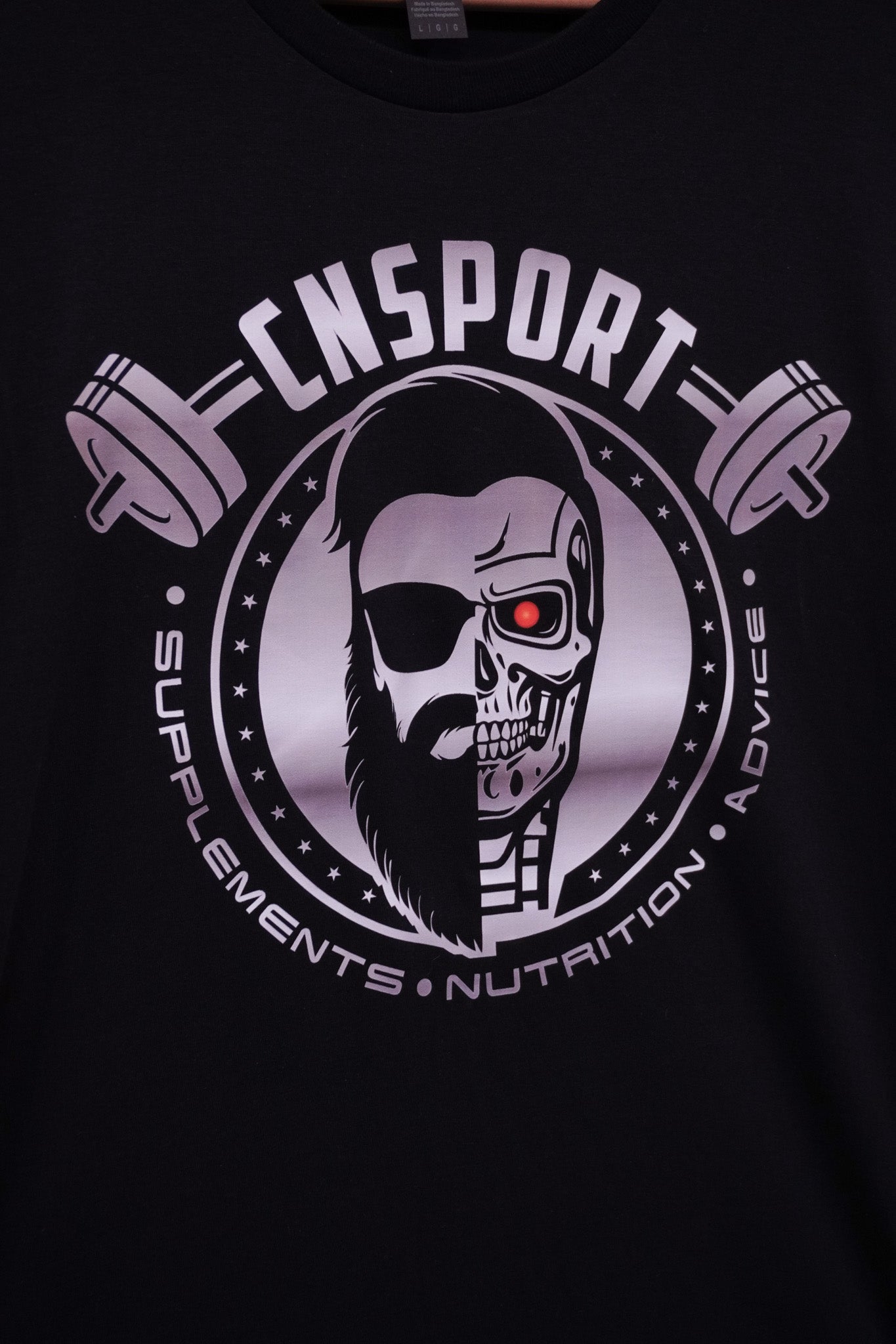 Close-up angled view of CNSport Terminator T-shirt graphic showing monochrome skull cyborg logo and red eye detail