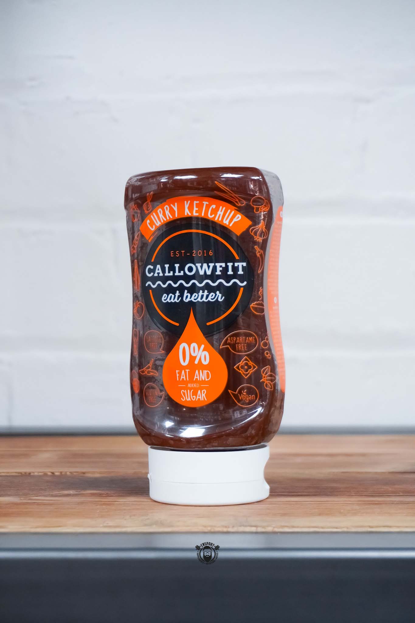 Callowfit Curry Ketchup Sauce 300ml bottle with 0% fat and added sugar branding, lactose-free, gluten-free, vegan and aspartame-free, displayed on a wooden countertop.