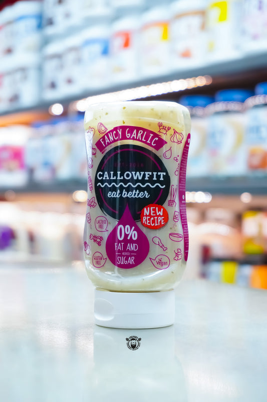 Callowfit Fancy Garlic Sauce 300ml bottle with new recipe label, 0% fat and added sugar branding, lactose-free, gluten-free and vegan-friendly, displayed in a supplement store.