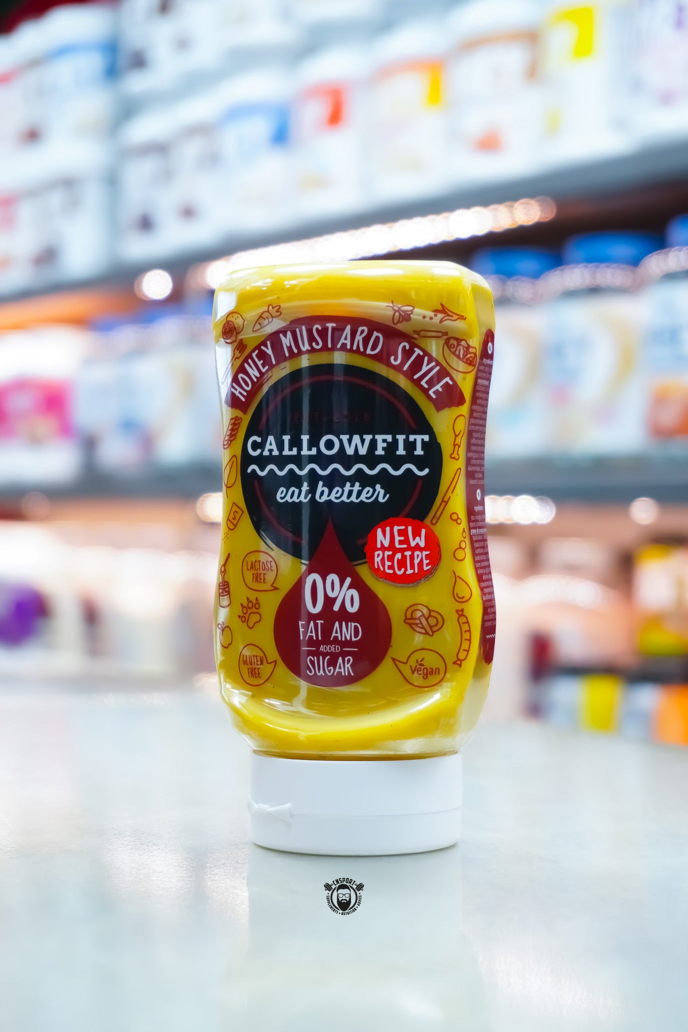 Callowfit Honey Mustard Style Sauce 300ml bottle featuring new recipe branding, 0% fat and added sugar, displayed upright in a supplement store.