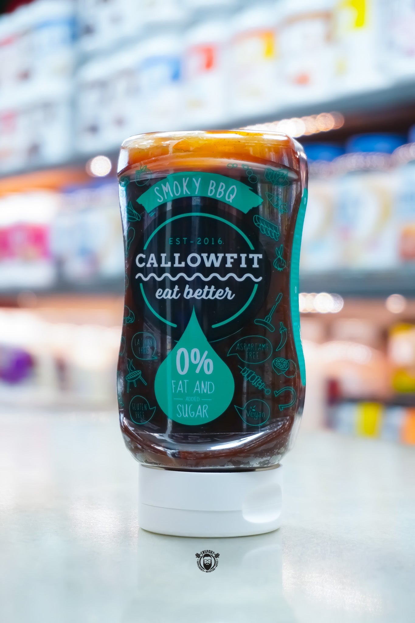 Callowfit Smoky BBQ Sauce 300ml bottle with 0% fat and added sugar branding, lactose-free, gluten-free, vegan and aspartame-free, displayed upright in a supplement store.