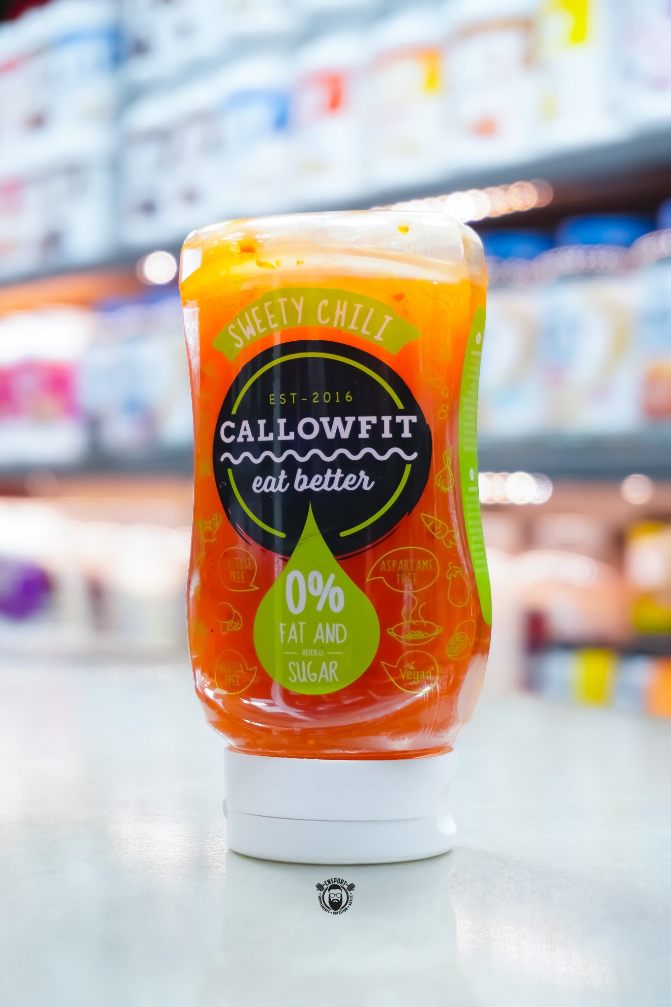 Callowfit Sweet Chili Sauce 300ml bottle featuring 0% fat and added sugar branding, lactose-free, gluten-free, vegan and aspartame-free, displayed upright in a supplement store.