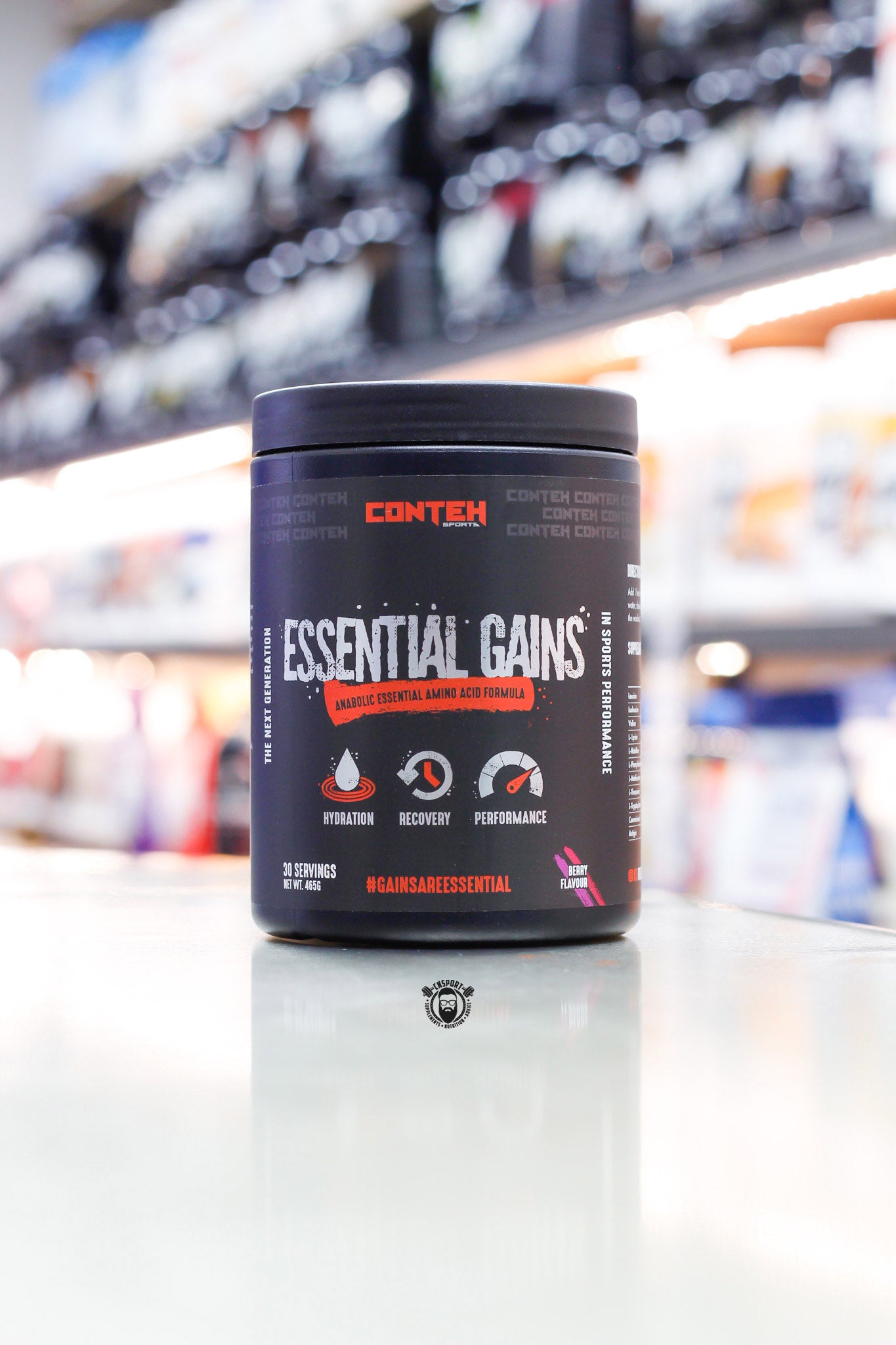 Conteh Sports Essential Gains EAA powder, berry flavour, 30 servings, black tub on supplement store counter.