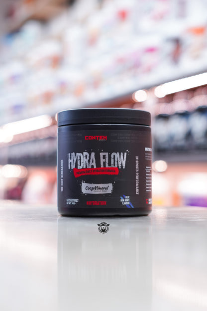 Conteh Sports Hydra Flow hydration powder in Blue Bon Bons flavour – 60 serving tub featuring CocoMineral, placed in retail store environment.