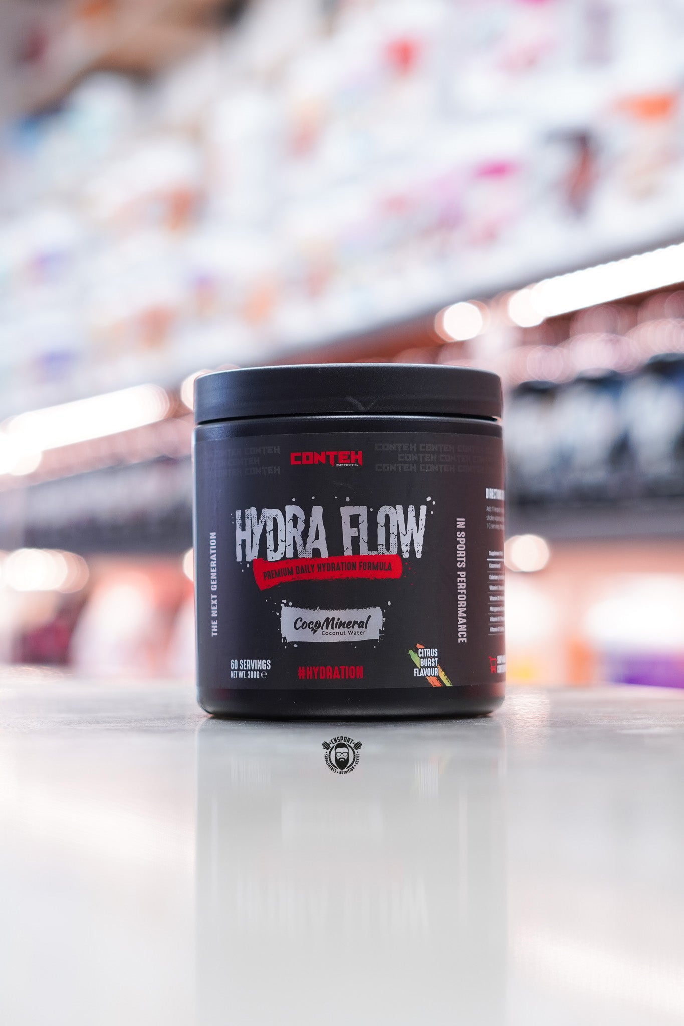 Conteh Sports Hydra Flow hydration drink mix in Citrus Burst flavour – 60 servings, black tub with red and citrus-themed accents, CocoMineral included.