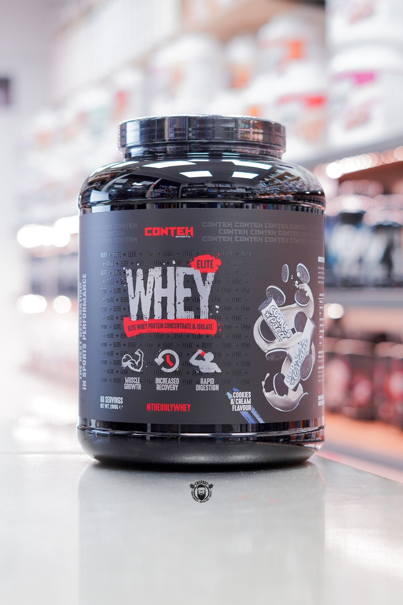 Conteh Sports Whey Elite protein powder, Cookies & Cream flavour, 66 servings (1.98kg) black tub displayed on supplement store counter.