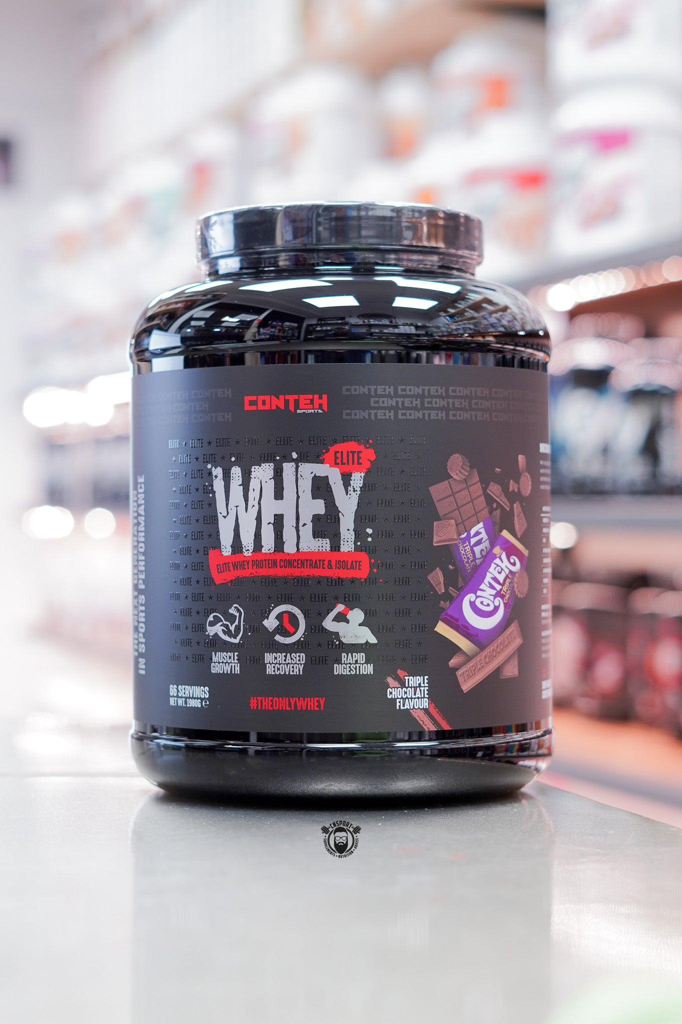Conteh Sports Whey Elite protein powder, Triple Chocolate flavour, 66 servings (1.98kg) black tub displayed on supplement store counter.