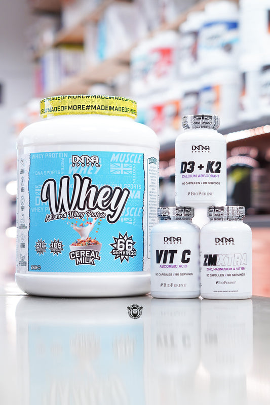 DNA Sports supplement bundle including Whey Advanced Whey Protein Cereal Milk 2kg, D3 + K2, Vitamin C, and ZMXTRA ZMA capsules displayed on supplement store counter.