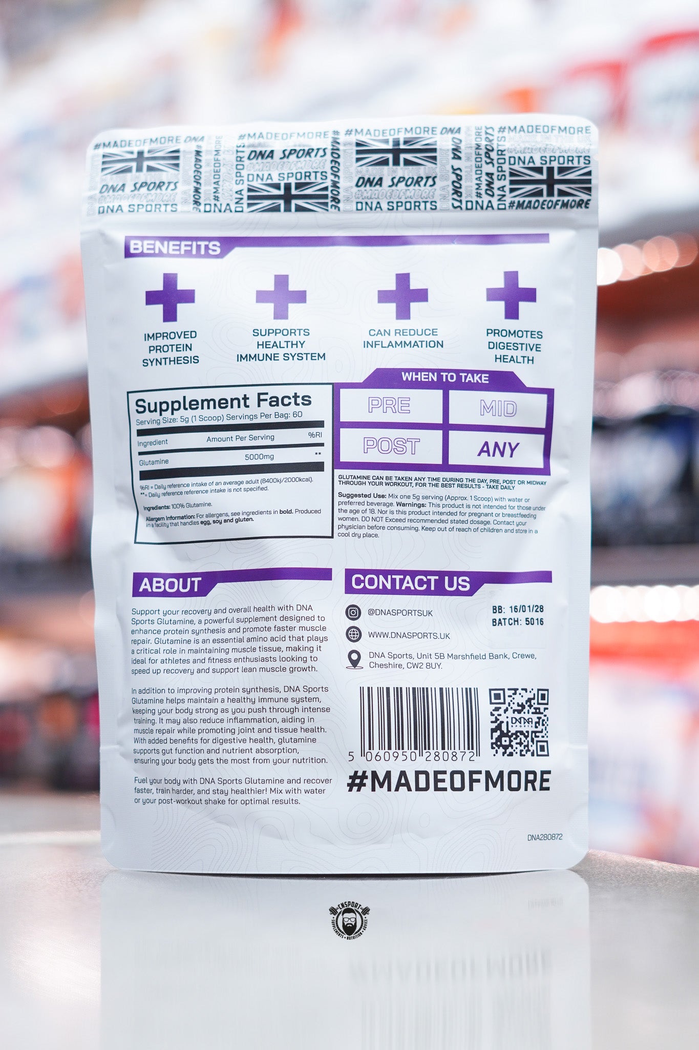 Back of a DNA Sports Glutamine 300g pouch showing benefits icons, supplement facts panel, usage guidance, product description, barcode, QR code, and brand contact details. The packaging features a white background with purple accents and #MADEOFMORE branding.