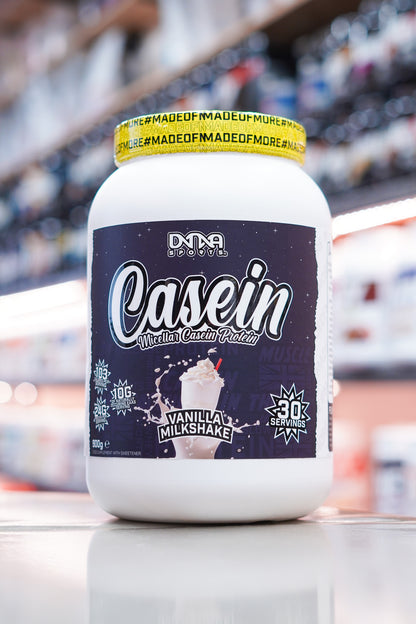 DNA Sports Casein Micellar Casein Protein Vanilla Milkshake 900g 30 servings tub on retail counter with blurred supplement store background