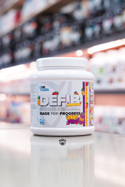 Front view of HR Labs Defib Proven pre-workout supplement tub in Fruit Punch flavour, displayed on a supplement store counter with a blurred retail background.