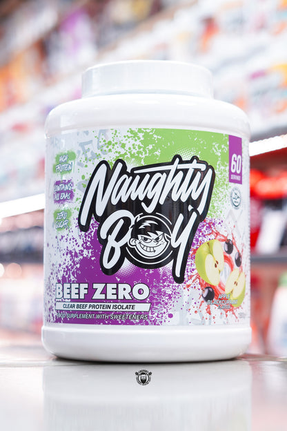 A large white tub of Naughty Boy Beef Zero clear beef protein isolate in Apple Blackcurrant flavour, featuring a green and purple splatter design with images of apples and blackcurrants on the label.