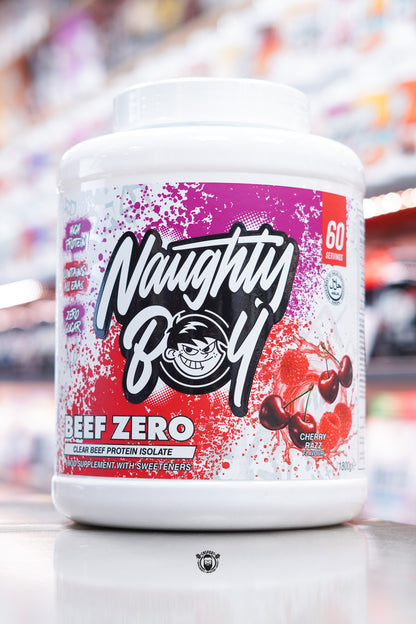 A large white tub of Naughty Boy Beef Zero clear beef protein isolate in Cherry Razz flavour, featuring a red and purple splatter design with cherries and raspberries pictured on the label.