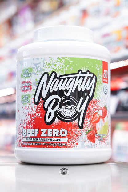 Front of Naughty Boy Beef Zero Strawberry Lime 1.8kg tub with green and red splatter design, Naughty Boy logo, and strawberry and lime imagery.