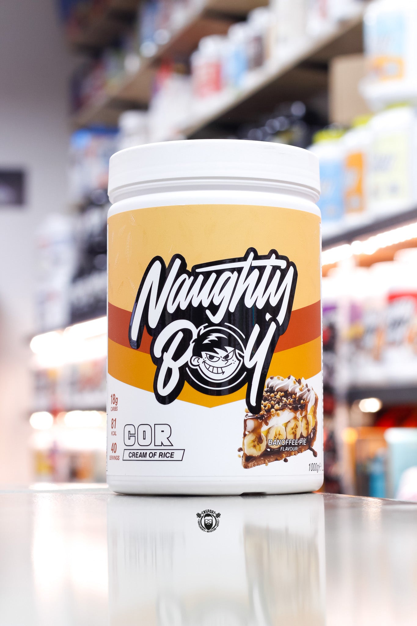 1kg Naughty Boy COR Cream of Rice in Banoffee Pie flavour, showcasing a yellow and brown label with a rich banoffee pie image featuring banana slices and toffee drizzle.