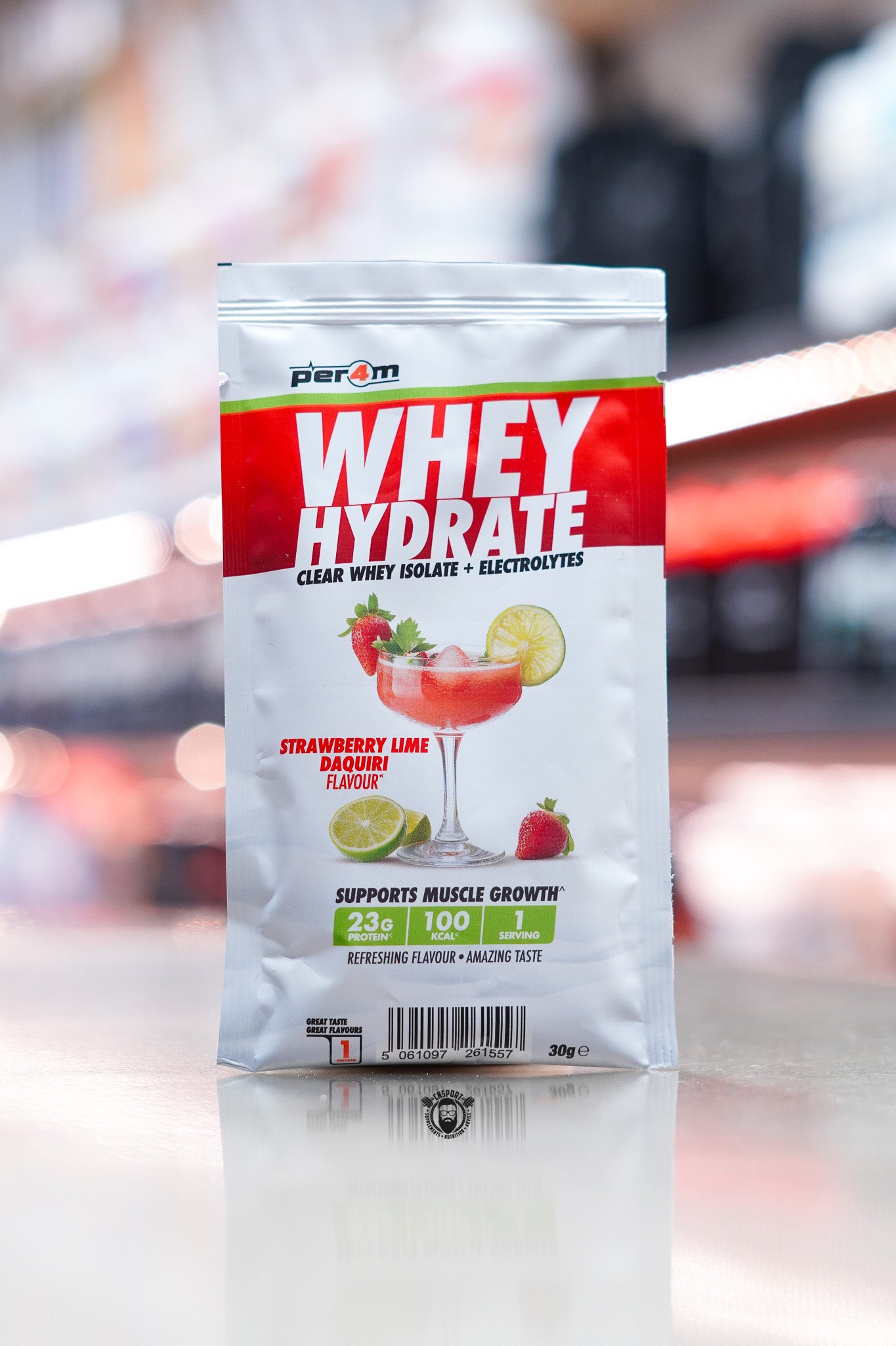 Per4m Whey Hydrate 30g sample sachet, Strawberry Lime Daiquiri flavour, clear whey isolate with electrolytes, displayed on counter in supplement store.