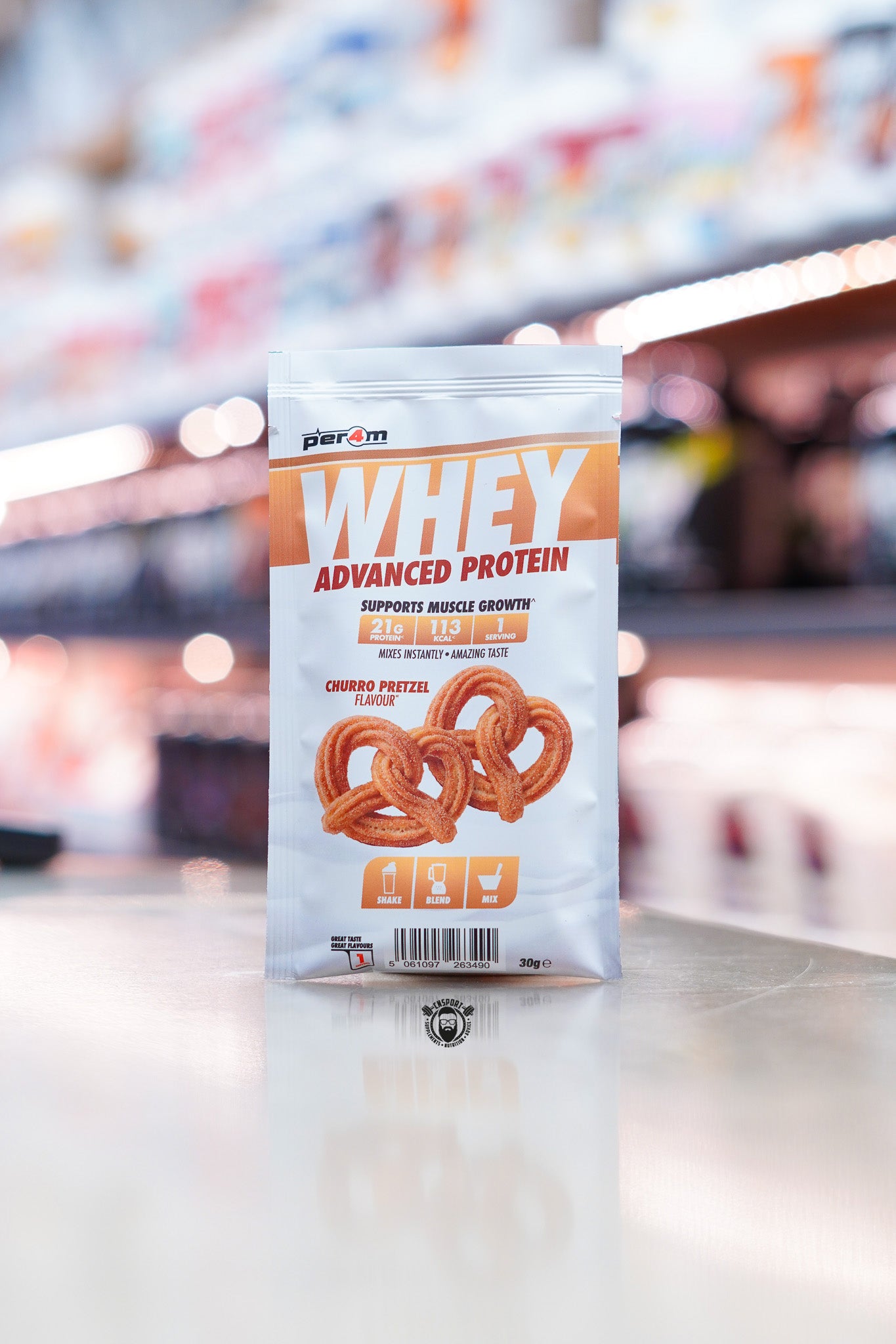 Per4m Advanced Whey Protein sample sachet, Churro Pretzel flavour, displayed on supplement store counter.