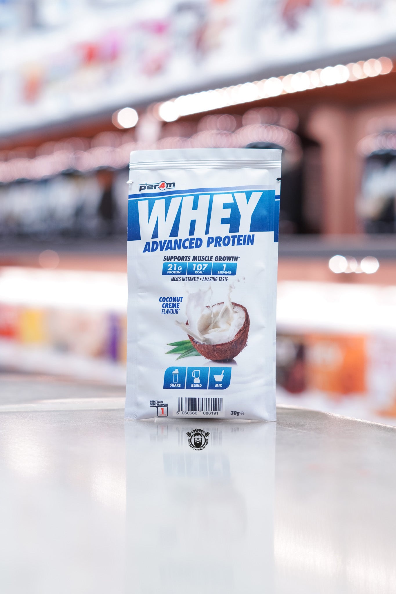 Front of a Per4m Whey Advanced Protein sample pouch in Coconut Crème flavour, showing 21g protein, 107 kcal, and 1 serving. Features an image of cracked coconut and shake/blend/mix icons.