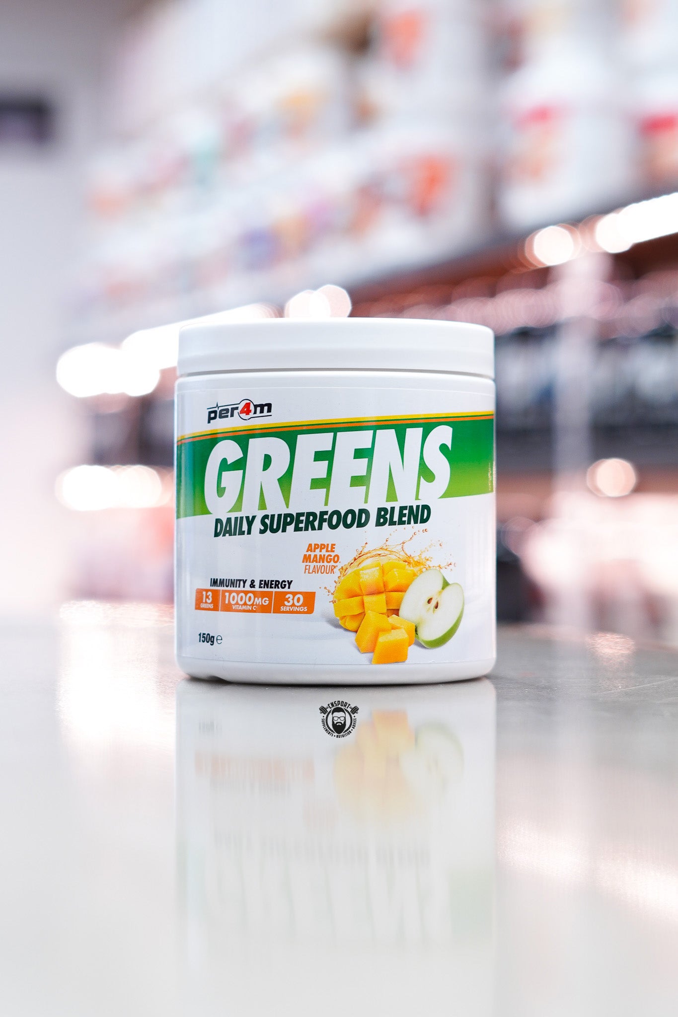 Per4m Greens daily superfood blend powder, apple mango flavour, 30 servings tub on supplement store counter.