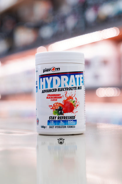 Per4m Hydrate Advanced Electrolyte Mix in Strawberry Blackcurrant flavour, featuring 2g taurine, CocoMineral®, 15 servings and a daily hydration formula, displayed on a supplement store counter.